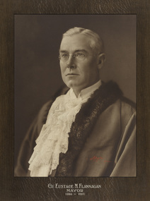 Black and white photograph a formal portrait chest up of seated man wearing mayoral robes with fur trims and jabot.
