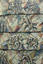 Photograph of a close up of a ceramic mural with depictions of abstracted figures