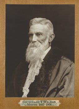Black and white formal portrait of man chest up, wearing mayoral robes with fur trims and lace  jabot. He has grey hair and long white beard