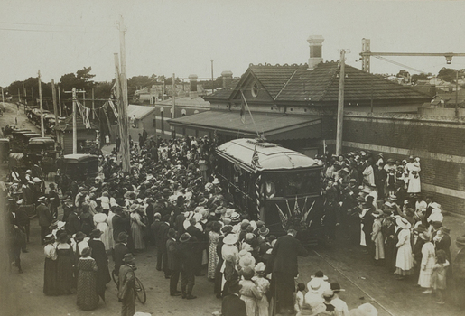 Back and white photograph of a crowd of people around a tram