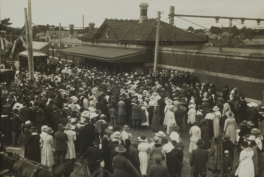 Black and white photograph of a large group gathered outside listening to a speech