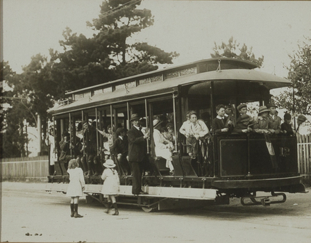 Black and white photograph of children on an open tram