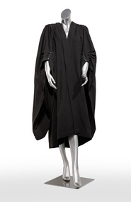 Photograph of a plain black ceremonial robe on a silver mannequin
