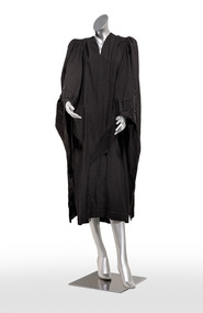 Photograph of a black ceremonial robe on a silver mannequin.