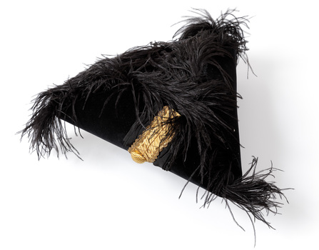 Photograph of a triangular shaped black velvet ceremonial hat with black ostrich feathers and gold coloured braid.