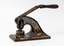 Black metal seal press with wooden handle, decorated with gold painted scrolls,