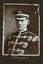 Black and white photograph of a man in uniform with his name written underneath on the mount