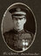 Black and white oval photograph of a man in uniform with his name written underneath on the mount