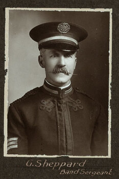 Black and white photograph of a man in uniform with his name written underneath on the mount
