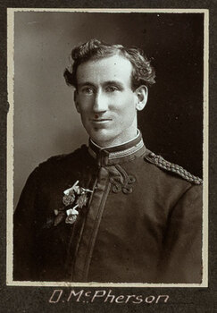 Black and white photograph of a man in uniform with his name written underneath on the mount