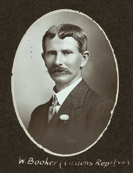 Black and white oval photograph of a man in a suit with his name written underneath on the mount