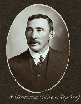 Black and white oval photograph of a man in a suit with his name written underneath on the mount