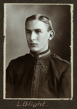Black and white photograph of a man in a uniform with his name written underneath on the mount