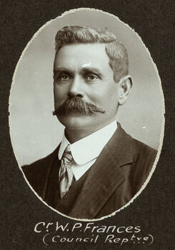 Black and white oval photograph of a man in a suit with his name written underneath on the mount