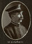 Black and white oval photograph of a profile of a man in a uniform and cap with his name written underneath on the mount