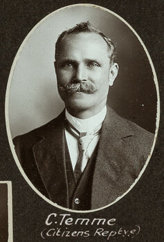 Black and white oval photograph of a man in a suit with his name written underneath on the mount