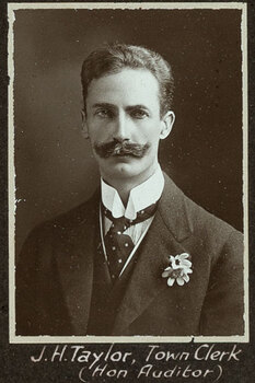Black and white photograph of a man in a suit with his name written underneath on the mount