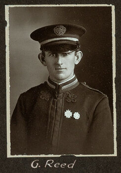 Black and white photograph of a man in a uniform and cap with his name written underneath on the mount