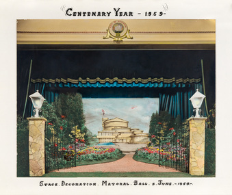 A hand-coloured photograph of a stage with dark curtains open to a set scene of the new Brighton Municipal Centre flanked by gardens.