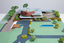 Architectural model of a cylindrical building in orange brick surrounded by gardens and paths