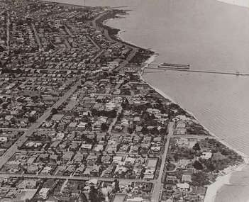 Black and white aerial photograph of Middle Brighton, the bay to the right, houses and streets to the left.