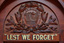 Detail of an honour board sowing a carved wreath containing City of Brighton Crest and below that gold and black lettering "LEST WE FORGET"