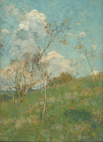 Open rural landscape with hill studded with trees in foreground and voluminous white clouds in a blue sky in background.