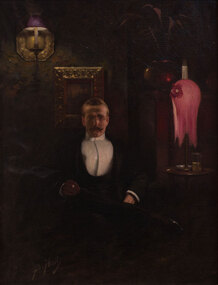 Dark interior with sitting moustached figure wearing glasses and dinner suit depicting male holding cigarette next to pink lamp on table with glass. There is a lamp and a painting hanging on the wall
