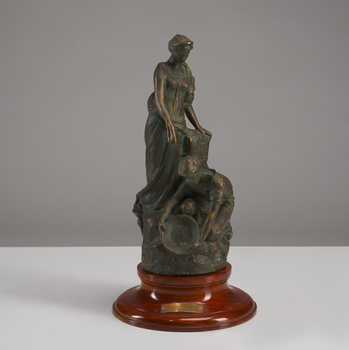 A man bends over panning for gold while anohter figure stands above him