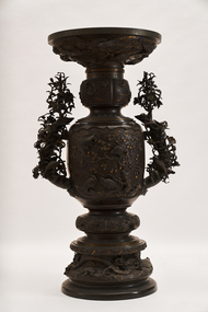 large decorative urn-style sculpture with four birds on one side and three birds on the other side