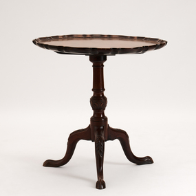 Round piecrust edge. Tripod base. Single pedestal. Claw feet. Carved scroll decoration on legs.