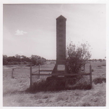 A BLACK AND WHITE PHOTO OF A MONUMENT DEPICTING THE DISCOVERY OF GOLD IN CLUNES. THE MONUMENT IS SITUATED AT NORTH CLUNES AND ERECTED BY THE CLUNES IN MELBOURNE CLUB.
