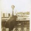 Black and white photograph of a young lady sitting on the balcony of the Club Hotel, Fraser Street, Clunes