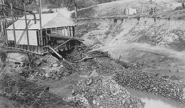 Barge with water pipes protuding from it, in open cut mine.