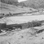 Wooden sluice flowing into dam.