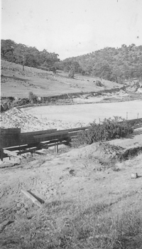 Wooden sluice flowing into dam.