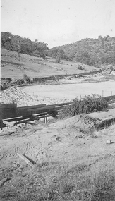 Wooden sluice flowing into dam.