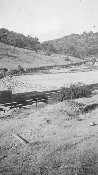 Wooden sluice flowing into dam.