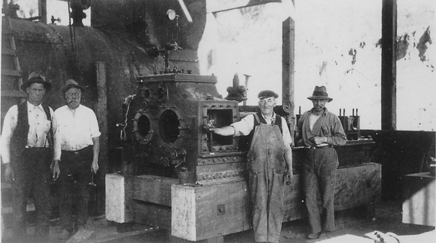 Four men standing in front of engine.