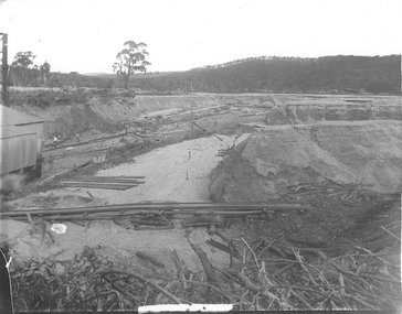 Open cut mine with sluice boxes of creek and part of processing shed.