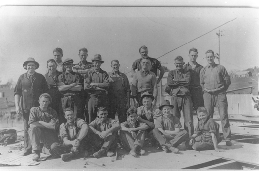 Nineteen men posing in a group photograph.