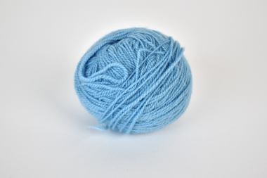 a ball of blue yarn with a grey-white background