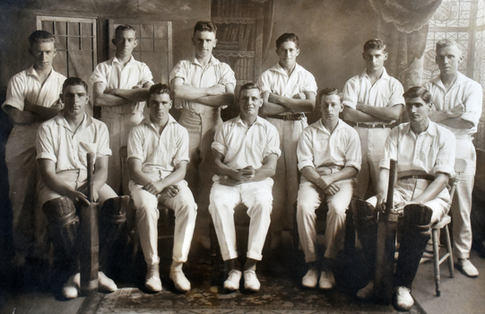 Group portrait of 11 white men in cricket uniforms