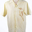 front view of a cream coloured shirt with a printed brown kookaburra on the right hand side