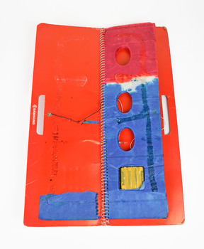view from above of folded blue paper lantern attached with a ring binder spine to red card