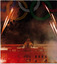 building lit with red lights and fireworks above, graphic of olympic rings at top of page