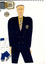 hand drawn image of a white man wearing black pants, black suit jacket, yellow shirt and a striped tie. Line drawing sketches show detail of shoes, jacket and belt to the left of figure.