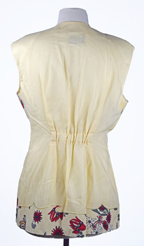 back view of cream sleeveless shirt with native botanical pattern at the bottom