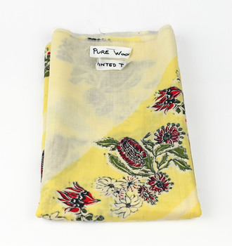 folded fabric showing yellow and cream background with printed native botanical design
