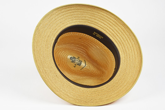 underside of straw hat showing black leather band and inscriptions